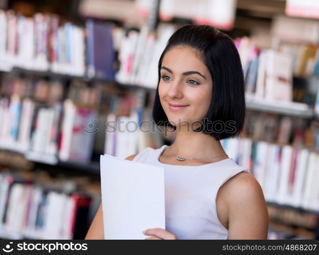 Happy female student at the library. Happy young female student sudying at the library