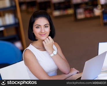 Happy female student at the library. Happy young female student sudying at the library