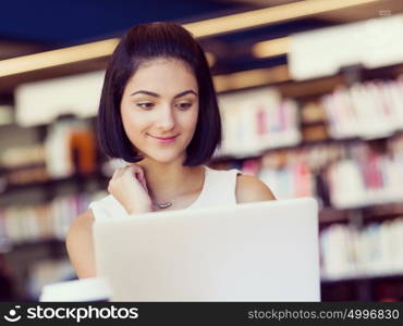 Happy female student at the library. Happy young female student sudying at the library