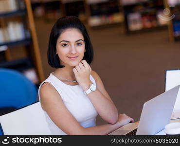 Happy female student at the library. Happy young female student sudying at the library