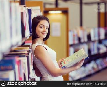 Happy female student at the library. Happy young female student sudying at the library