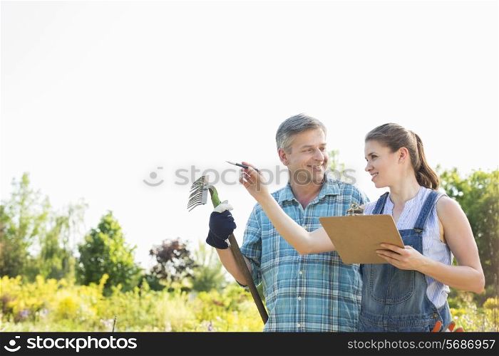 Happy female supervisor explaining something to gardener at plant nursery