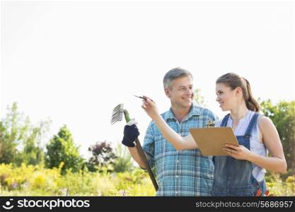 Happy female supervisor explaining something to gardener at plant nursery