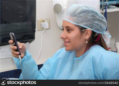 happy female surgeon reading message at mobile phone