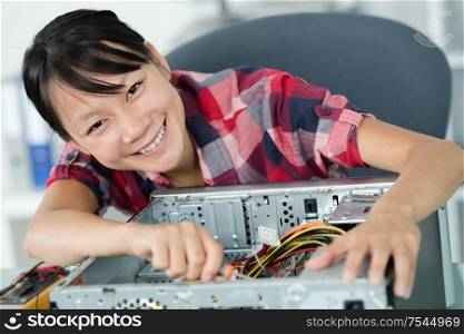 happy female technician repairing a computer