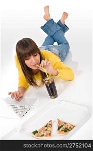 Happy female teenager with laptop, pizza and cola lying down