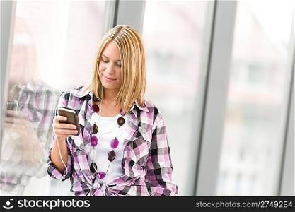 Happy female teenager with mp3 player listen to music