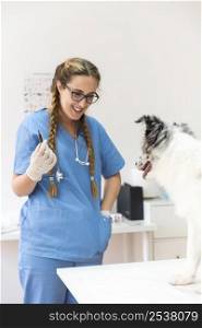 happy female vet with injection looking dog table