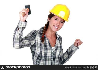Happy female worker holding hammer