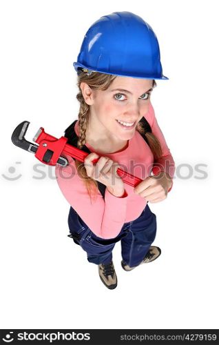 Happy female worker holding wrench