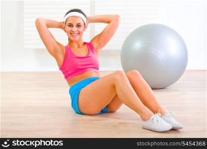 Happy fitness girl doing abdominal crunch on floor at home&#xA;
