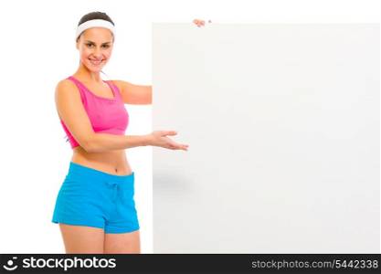 Happy fitness girl in sportswear holding blank billboard isolated on white&#xA;