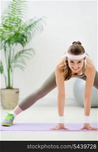 Happy fitness woman doing stretching exercises