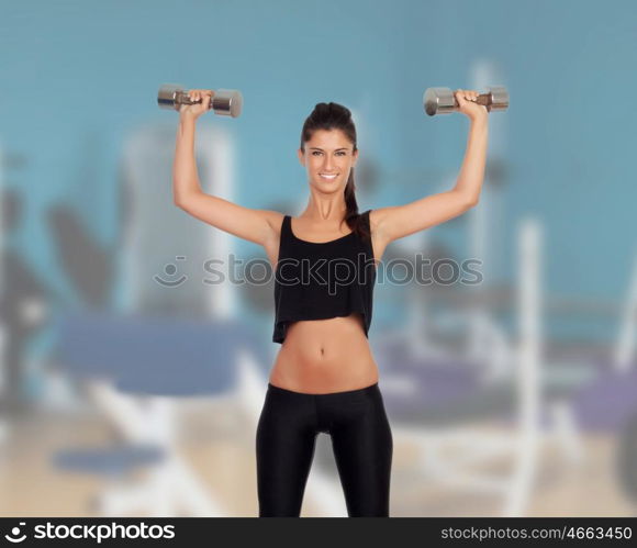 Happy fitness woman lifting dumbbells in the gym
