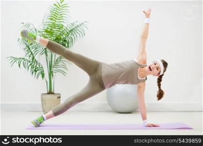 Happy fitness woman making gymnastics on floor