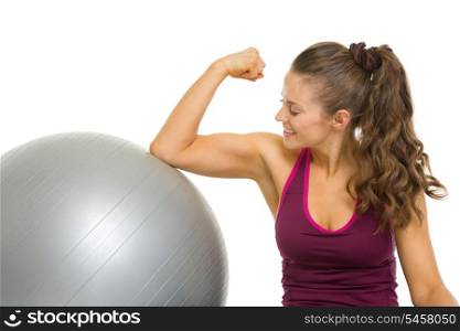 Happy fitness young woman checking biceps