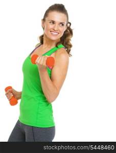 Happy fitness young woman making exercise with dumbbells and looking on copy space
