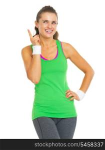 Happy fitness young woman pointing on copy space