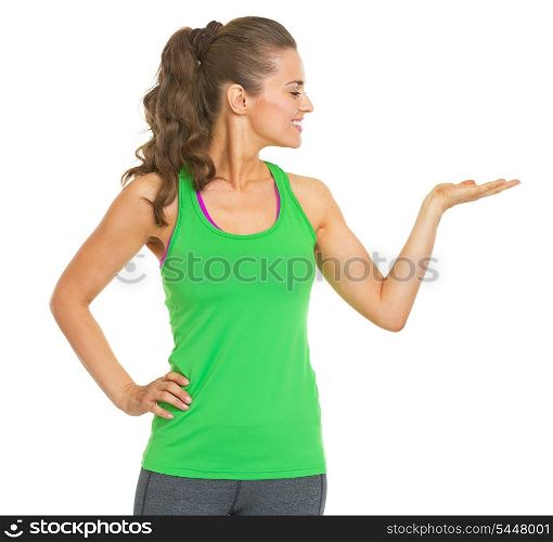 Happy fitness young woman presenting something on empty palm