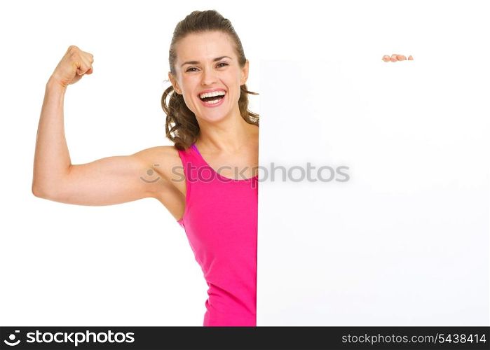 Happy fitness young woman showing biceps and blank billboard