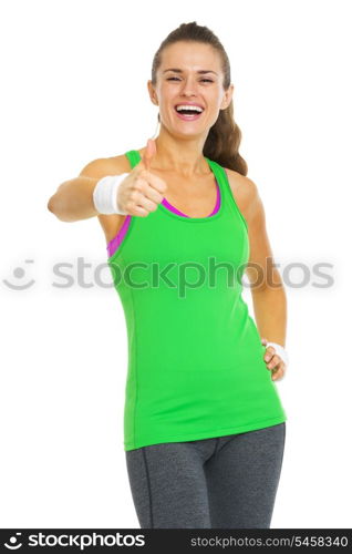 Happy fitness young woman showing thumbs up