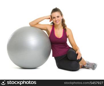 Happy fitness young woman sitting near fitness ball