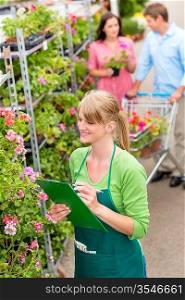 Happy florist woman make inventory at garden shopping center