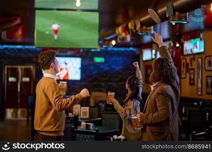 Happy football fans cheering drinking beer and watching soccer match translation on tv at sport bar. Happy football fans cheering drinking beer and watching soccer match