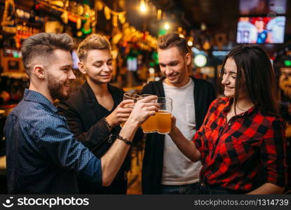 Happy football fans raised their glasses with beer at the bar counter in a sport pub, victory celebration. Happy football fans raised their glasses with beer