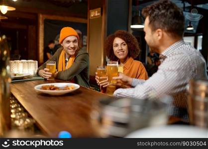 Happy friends drinking beer sitting at bar counter desk. Young people sharing impression about last game of favorite team while rest at sports pub. Selective focus. Happy friends drinking beer while rest sitting at bar counter desk