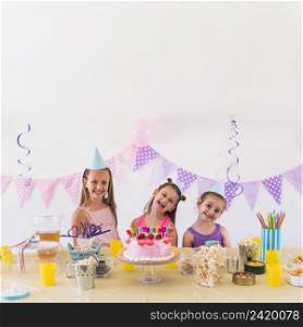 happy friends enjoying birthday party with tasty snack cake table