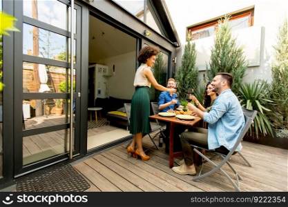Happy friends grilling food and enjoying barbecue party outdoors
