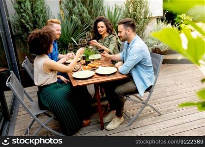Happy friends grilling food and enjoying barbecue party outdoors
