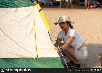 Happy friends pitch tent on sand at beach together to sea in holiday vacation time at sunset, Young Asian group woman and man in summer travel outdoor, C&ing people outdoor lifestyle