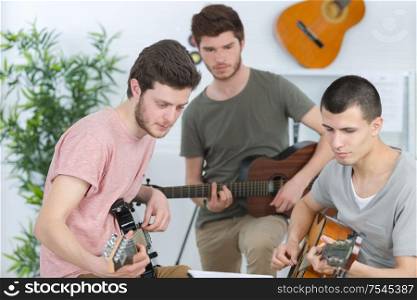 happy friends playing guitarat home