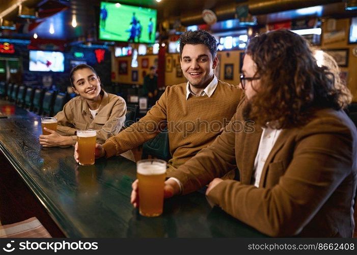 Happy friends resting and talking at sport bar. Group of excited people having beers pub. Friendship and fun time together. Group of happy friends resting and talking at bar or pub
