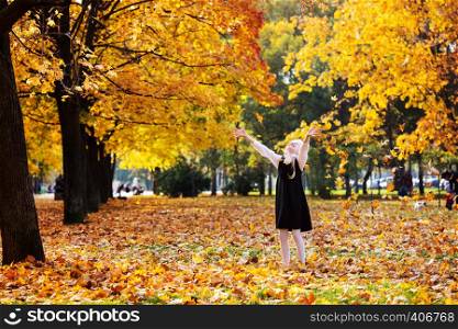 happy fun schoolgirl is walking in the park on a fall day. Autumn Walk