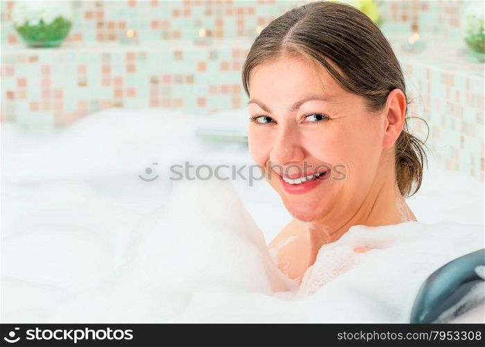 happy girl and full bath foam in the bathroom