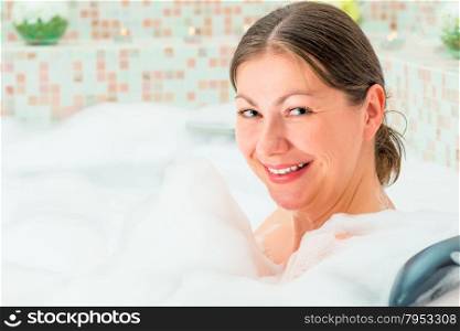 happy girl and full bath foam in the bathroom