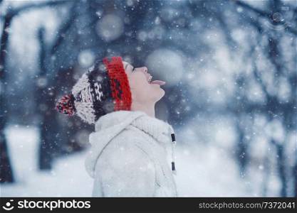 happy girl catches snowflakes mouth