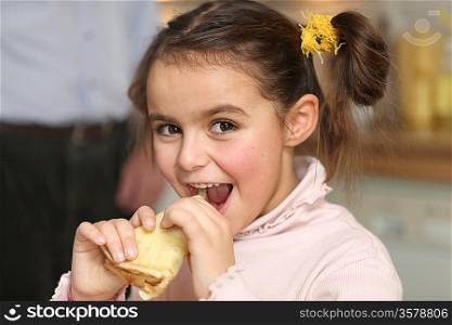 Happy girl eating a pancake