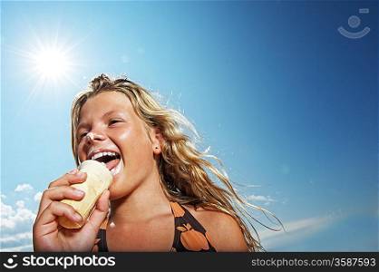 Happy girl eating icecream outdoors