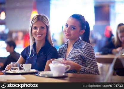 happy girl friends have cup of coffee in modern city restaurant