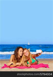 happy girl friends selfie portrait lying on beach sand in summer vacation