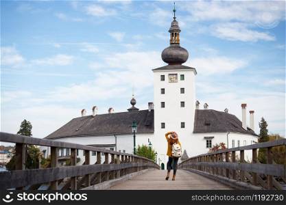 happy girl goes over the bridge to the castle ort, austria