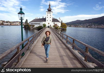 happy girl goes over the bridge to the castle ort, austria