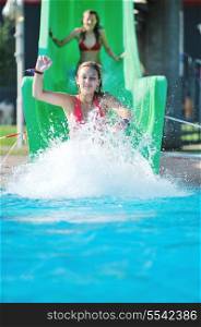happy girl have fun on water slide at outdoor swimming pool