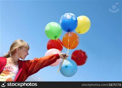 Happy Girl Holding Colorful Helium Balloons in the Sky in the Sunny Day