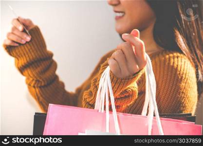 Happy girl holding the colorful shopping bag and credit card for. Happy girl holding the colorful shopping bag and credit card for family new year gift - applied matt soft focus filter