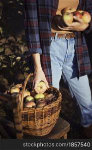 happy girl holds basket with juicy apples in the garden. aesthetics of rural life
